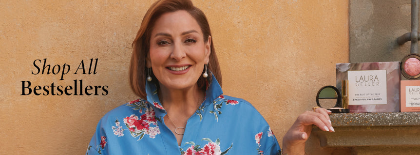 Laura Geller in a blue floral blouse holding a the Laura Geller product line.