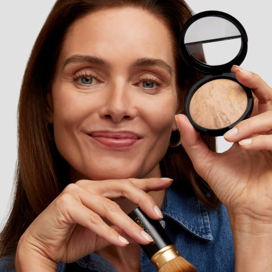 Woman holding Baked Balance-n-Brighten Foundation and Airbrush Kabuki Brush 