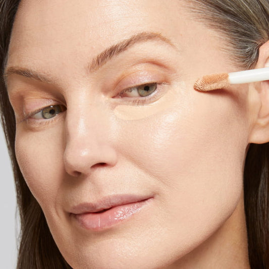 Model applying Ideal Fix Concealer on her under eyes