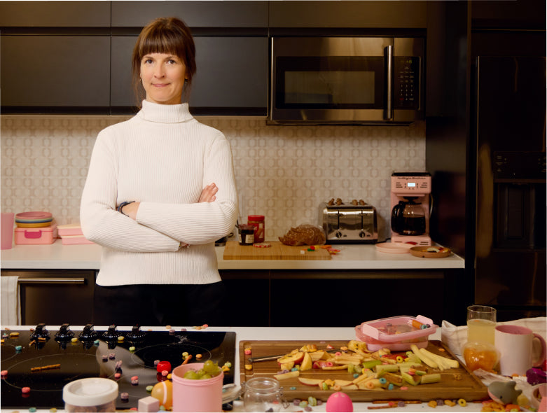 Woman standing in a kitchen with food preparation visible