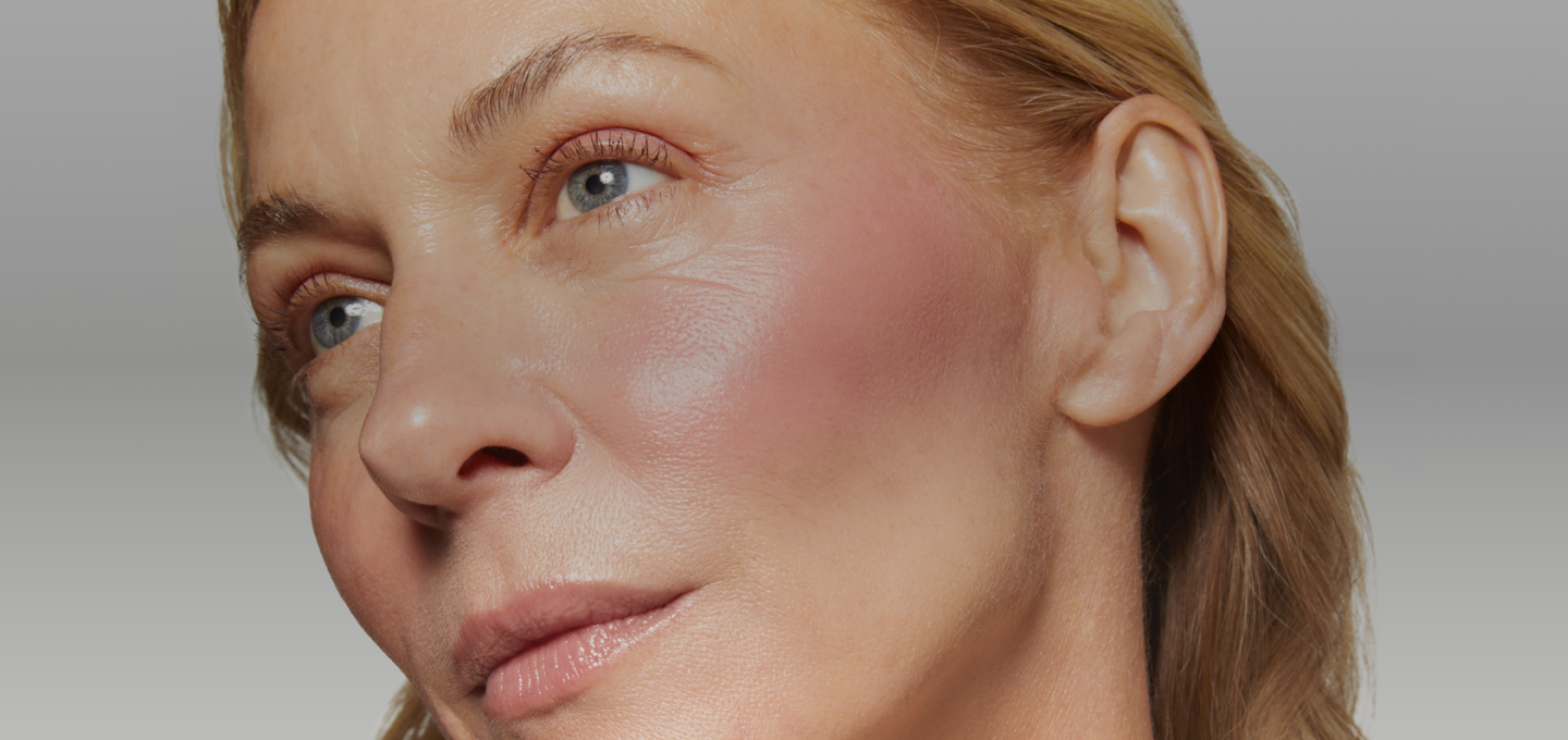 Close-up of a woman's face wearing Laura Geller's wonder Balm with a neutral background