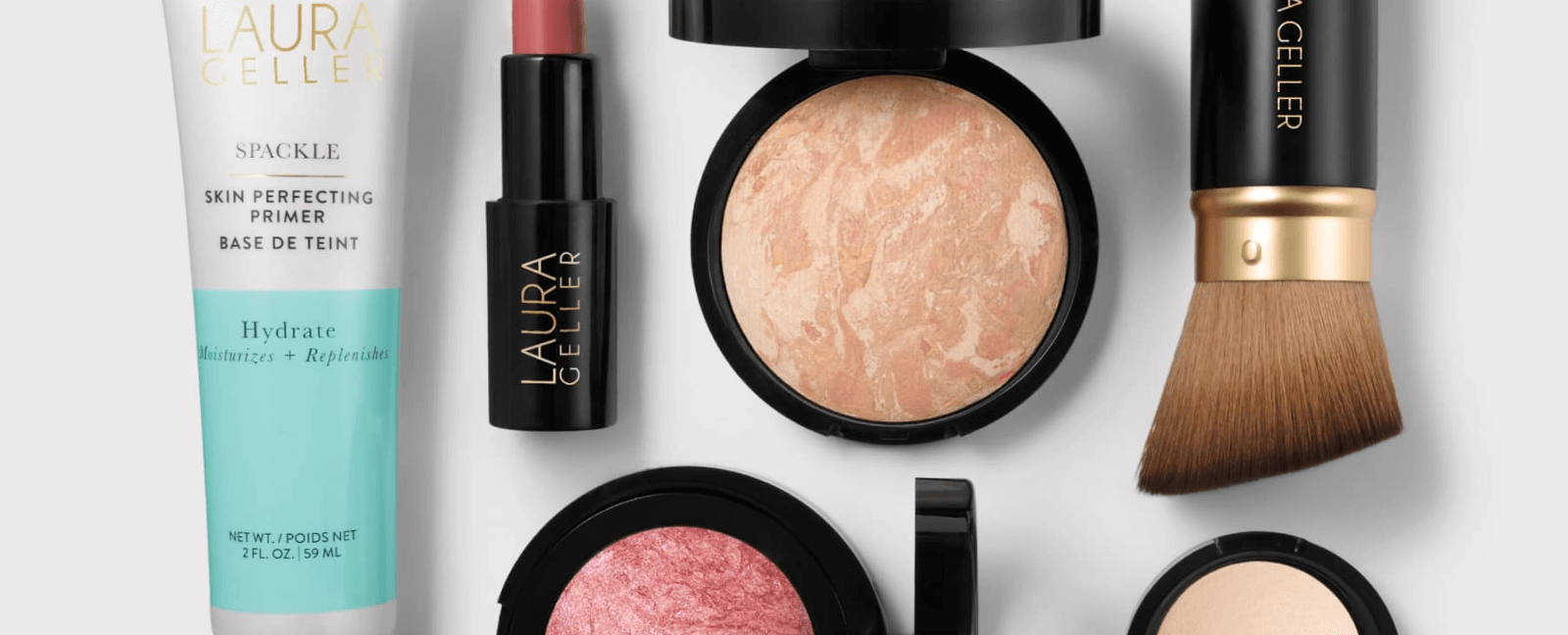 Collection of Laura Geller makeup products including a cream, brush, and compact on a white background.
